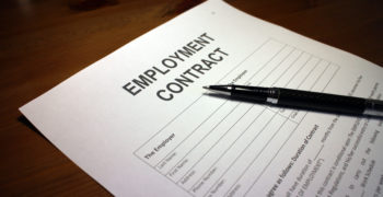 Someone filling out Contract of Employment.